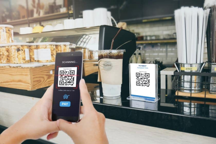 Customer paying at a cafe by scanning a Readies Pay QR code